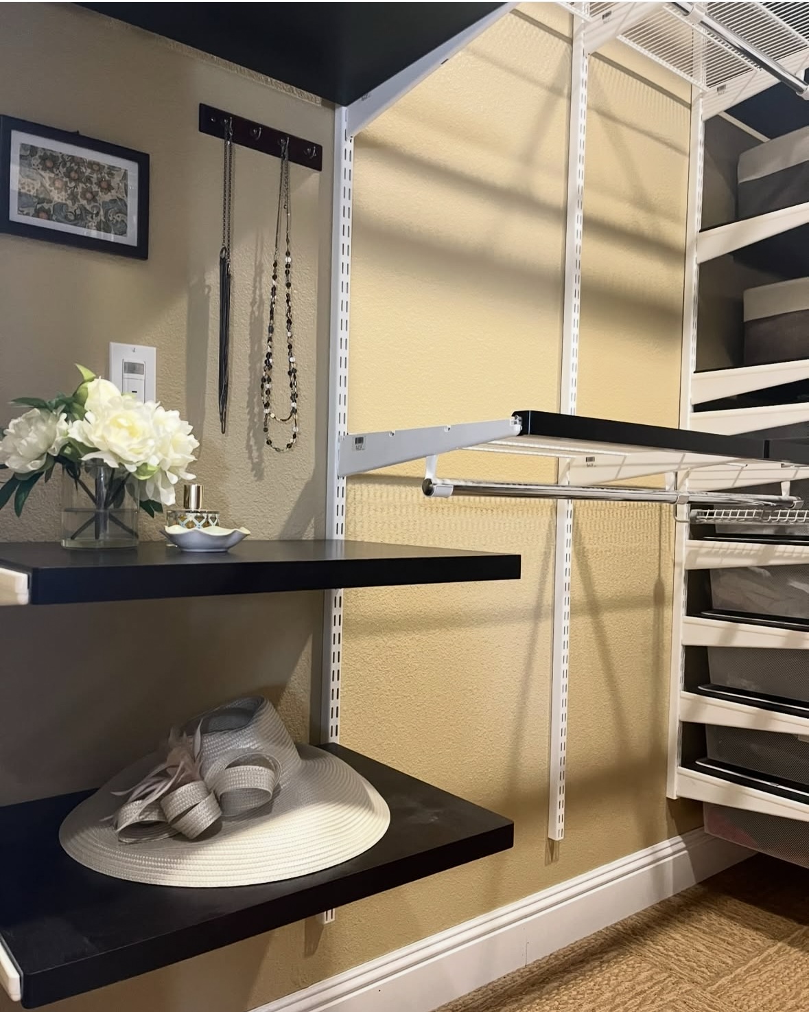 A photo of lovely walk-in ELFA closet with just a few items in it, it's mostly empty