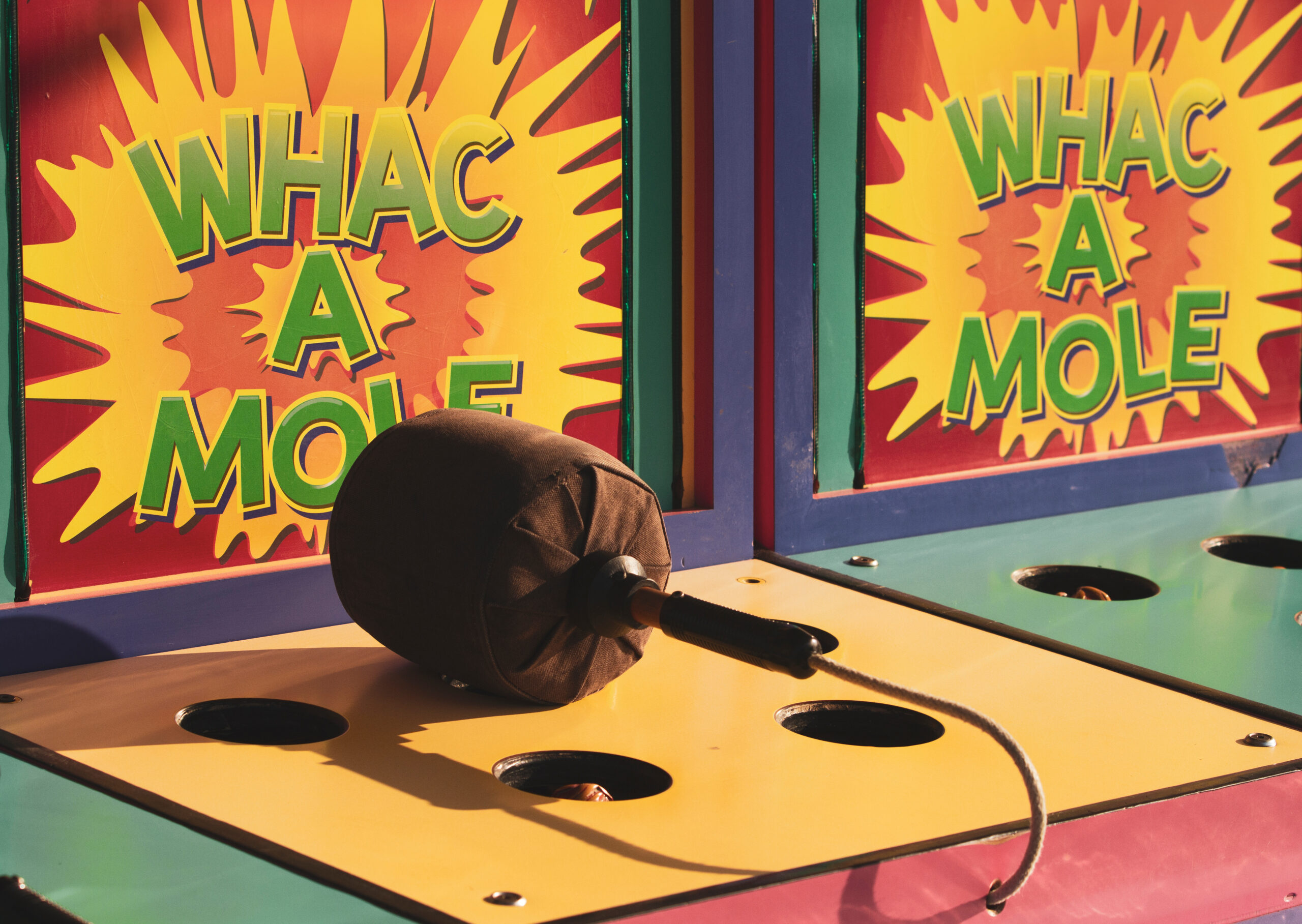 A colorful view of a Whack A Mole game at a carnival